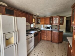 A mobile home kitchen with glass in the cabinet doors