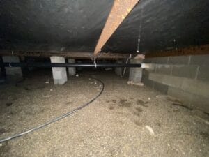 Underneath a mobile home showing the crawl space vapor barrier