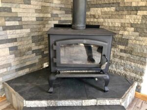 A small cast iron wood stove with brick backing