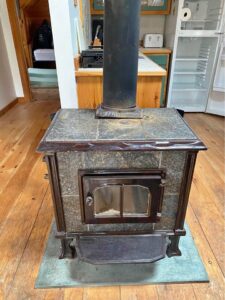 A small wood stove sitting on a wood floor