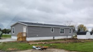 A gray mobile home with new siding