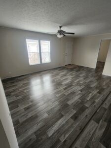 A large living room with vinyl flooring in a mobile home