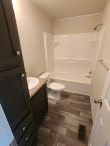 A bathroom in a mobile home with vinyl flooring
