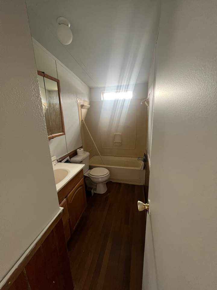 A bathroom with a window over the shower unit