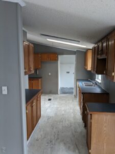 A kitchen in a mobile home with cupboards down each side of the wall