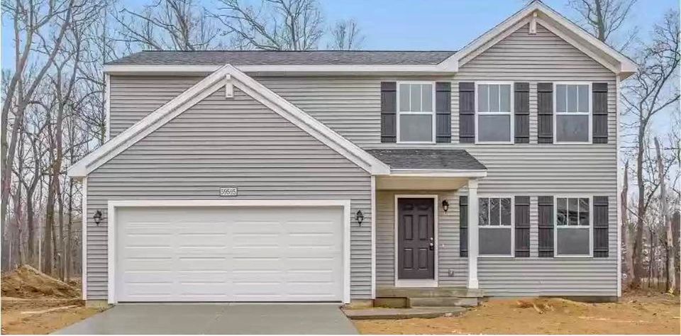 A large stick built gray home with dark shutters