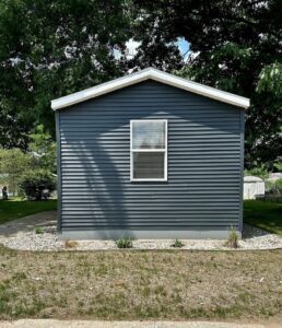 A small singlewide mobile home with white fascia