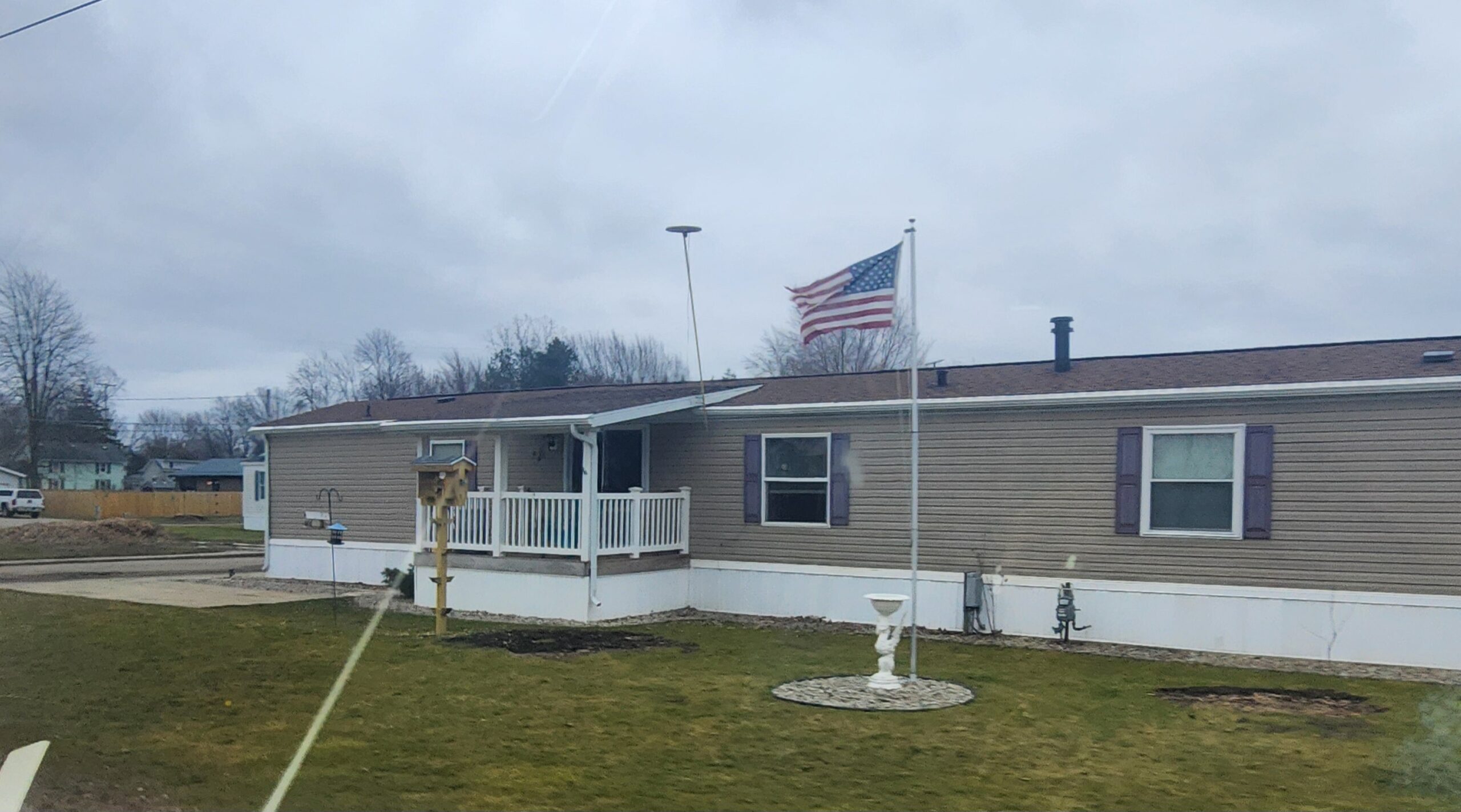 A singlewide with an American flag out front
