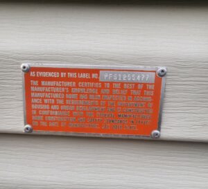 A HUD tag on the siding of a mobile home