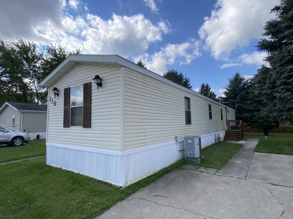 A yellow singlewide mobile home on private land