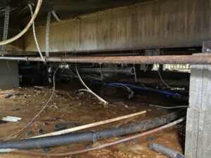 A view under a mobile home showing all the pipes