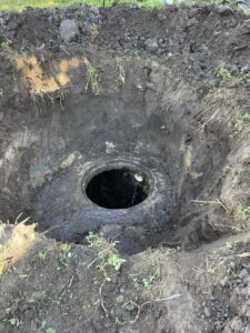 A whole in the ground where a septic tank sits