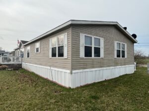 A tan colored doublewide with white trim