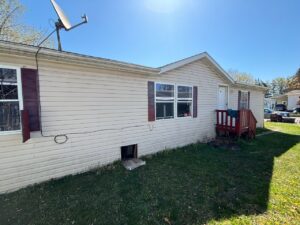 A cream colored doublewide with red shutters