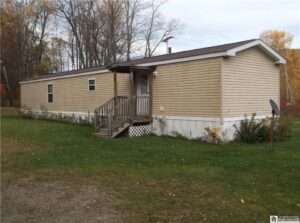 A porch attached to a mobile home with a roof