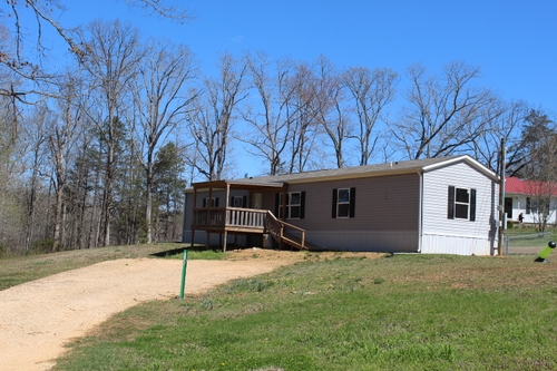 A large covered porch on a singlewide mobile home