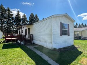 A long white trailer home with red shutters