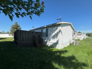 A doublewide mobile home with a large lawn