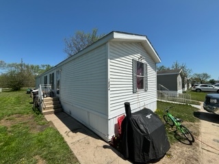 A white singlewide mobile home from the front