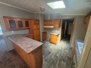 A kitchen inside a mobile home with oak cupboards