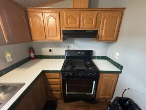 A kitchen with oak cupboards and a black stove