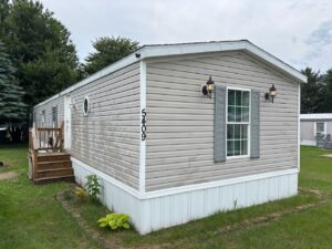 Gray manufactured home with address numbers in residential mobile home park