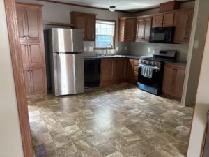 Updated mobile home kitchen with wood cabinets and stainless steel appliances
