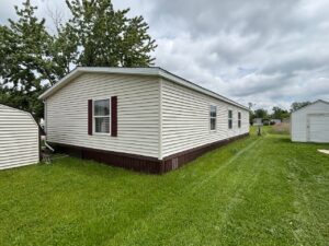 Well-maintained mobile home with red shutters in Texas