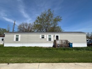 Single-wide mobile home with front deck and steps